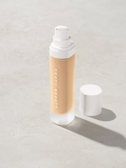 open bottle of Fenty Beauty Pro Filt'r Soft Matte Longwear Foundation with pump dispenser in shade #185 on concrete background