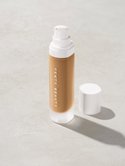 open bottle of Fenty Beauty Pro Filt'r Soft Matte Longwear Foundation with pump dispenser in shade 345 on concrete background