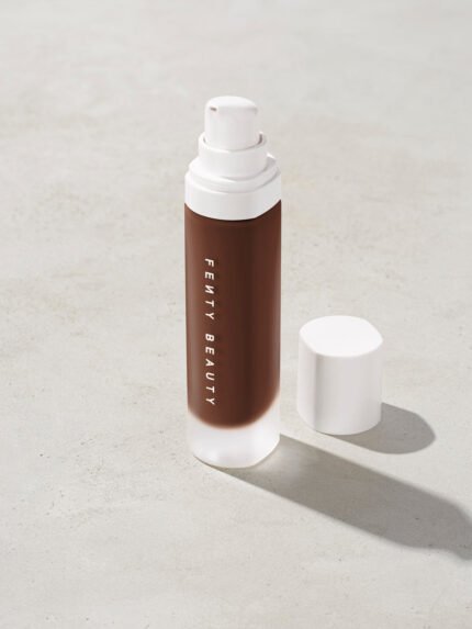 open bottle of Fenty Beauty Pro Filt'r Soft Matte Longwear Foundation with pump dispenser in shade 495 on concrete background