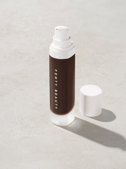 open bottle of Fenty Beauty Pro Filt'r Soft Matte Longwear Foundation with pump dispenser in shade 498 on concrete background