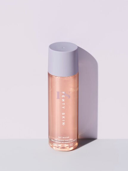 A bottle of Fat Water Toner Serum against a lilac backdrop.