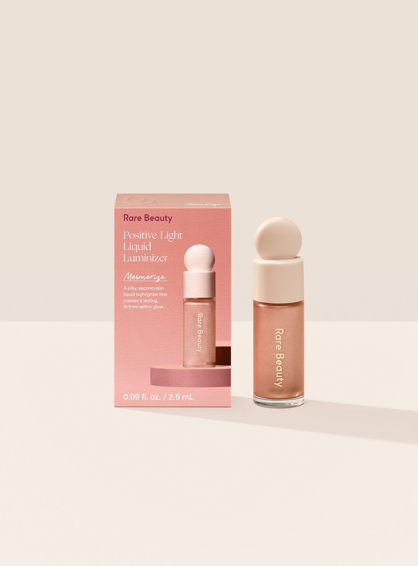 ECOMM-MINI-POSITIVE-LIGHT-LIQUID-LUMINZER-MESMERIZE-PRODUCT-BOX Mesmerize| Rare Beauty's Positive Light Liquid Luminizer Mini in the rose bronze shade Mesmerize.