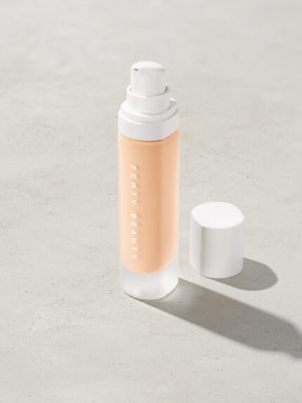 open bottle of Fenty Beauty Pro Filt'r Soft Matte Longwear Foundation with pump dispenser in shade #110 on concrete background