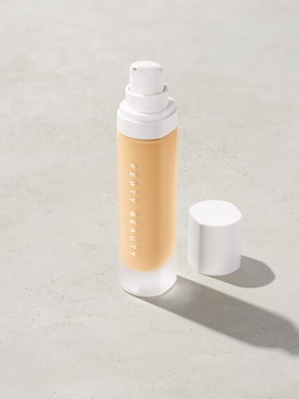 open bottle of Fenty Beauty Pro Filt'r Soft Matte Longwear Foundation with pump dispenser in shade #130 on concrete background