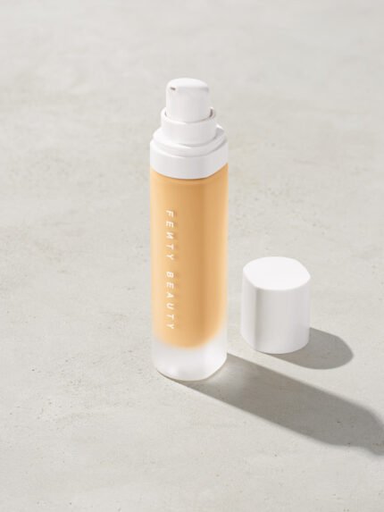 open bottle of Fenty Beauty Pro Filt'r Soft Matte Longwear Foundation with pump dispenser in shade #140 on concrete background