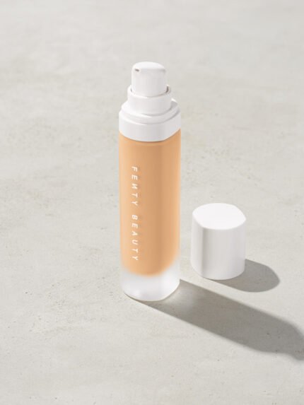 open bottle of Fenty Beauty Pro Filt'r Soft Matte Longwear Foundation with pump dispenser in shade #210 on concrete background
