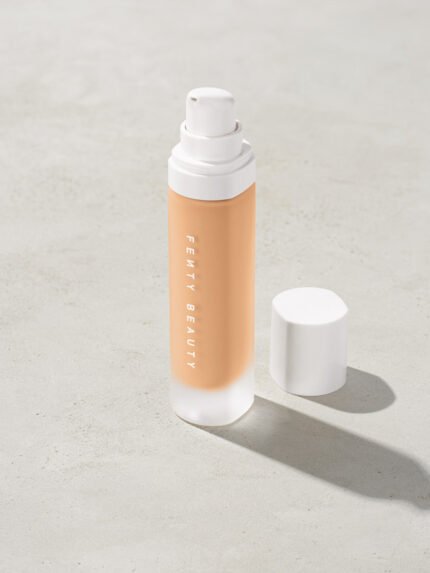 open bottle of Fenty Beauty Pro Filt'r Soft Matte Longwear Foundation with pump dispenser in shade #220 on concrete background