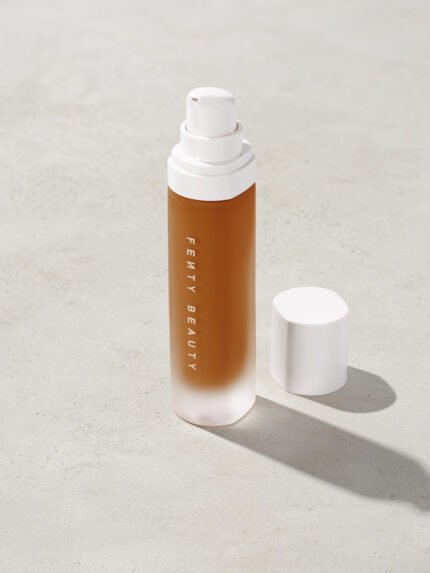 open bottle of Fenty Beauty Pro Filt'r Soft Matte Longwear Foundation with pump dispenser in shade 400 on concrete background