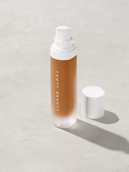 open bottle of Fenty Beauty Pro Filt'r Soft Matte Longwear Foundation with pump dispenser in shade 410 on concrete background