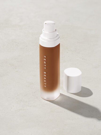 open bottle of Fenty Beauty Pro Filt'r Soft Matte Longwear Foundation with pump dispenser in shade 430 on concrete background