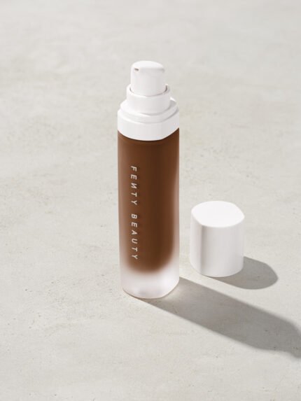 open bottle of Fenty Beauty Pro Filt'r Soft Matte Longwear Foundation with pump dispenser in shade 490 on concrete background