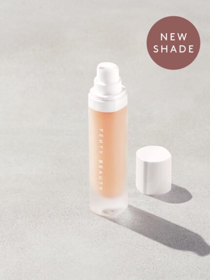 Open bottle of Fenty Beauty Pro Filt'r Soft Matte Longwear Foundation with pump dispenser in shade #125 on concrete background