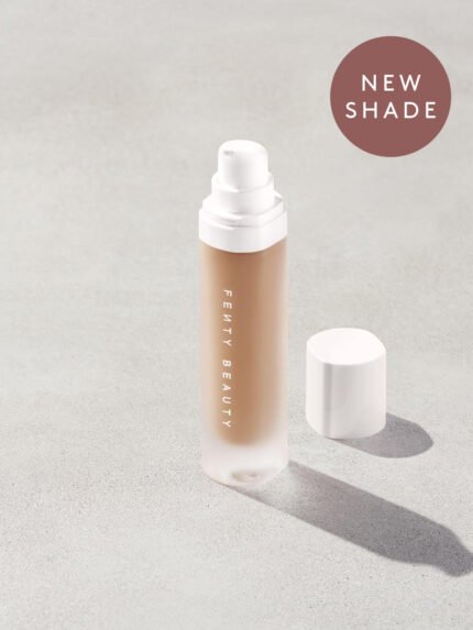 Open bottle of a new shade of Fenty Beauty Pro Filt'r Soft Matte Longwear Foundation with pump dispenser in shade #295 on concrete background