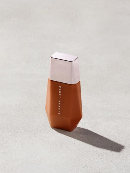 Eaze Drop’Lit All-Over Glow Enhancer shown in shade Bronze Jasper on a concrete background. 