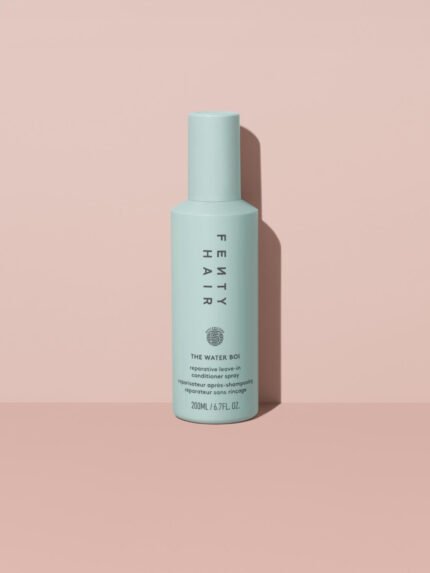 The Water Boi Reparative Leave-In Conditioner Spray on a peach background.