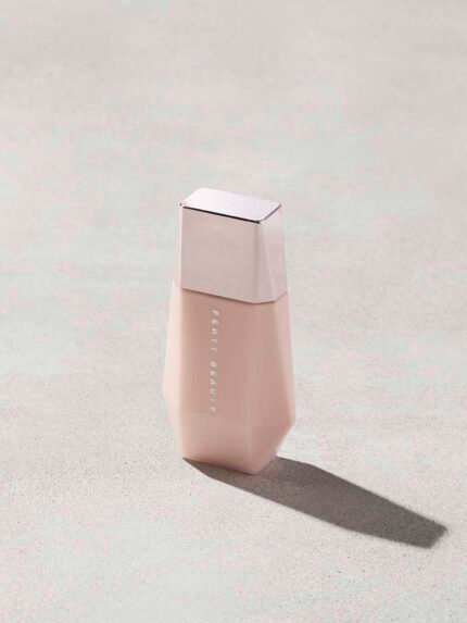 Eaze Drop’Lit All-Over Glow Enhancer shown in shade Pink Pearl on a concrete background. 